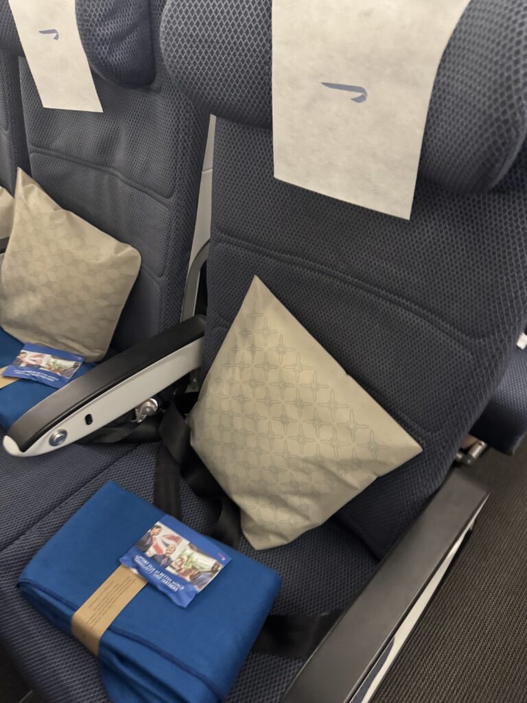British Airways Economy seat with pillow and amenity kit