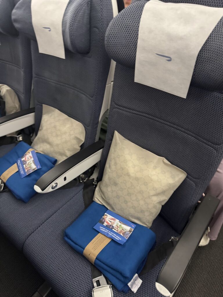 British Airways Economy Class seat with pillow and blanket