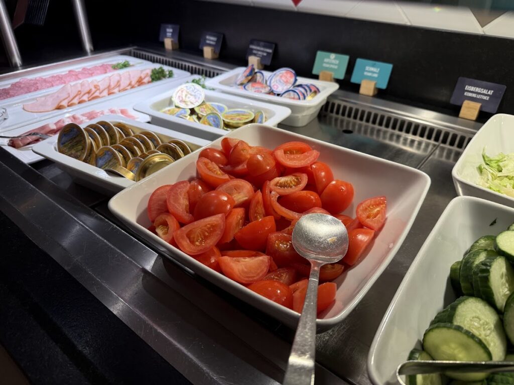 Breakfast buffet with tomatoes, meats, and vegetables