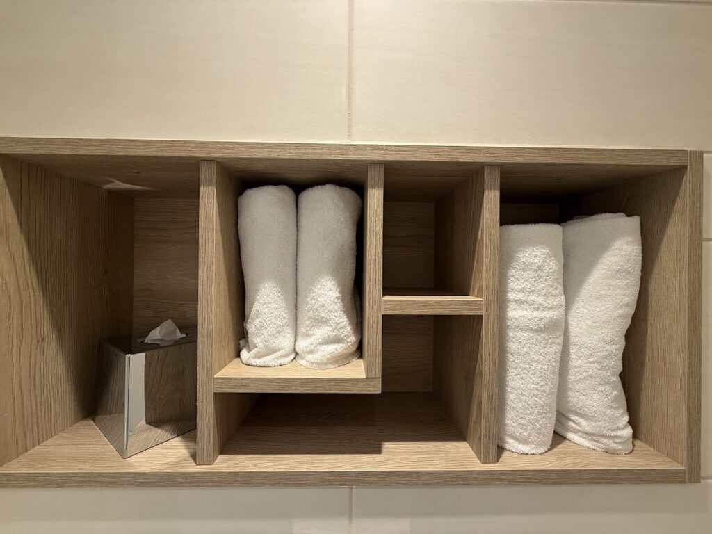 Hotel room storage shelf with rolled towels