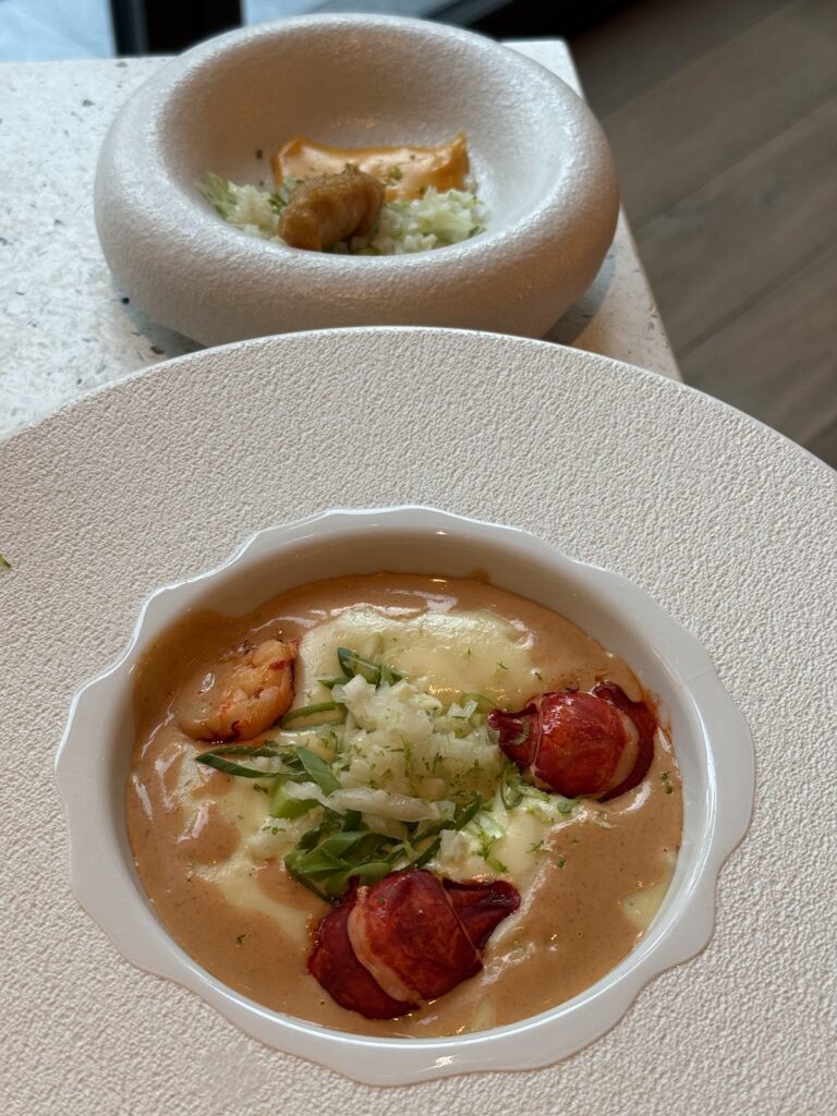 Gourmet seafood dish with shrimp, risotto, and tomato