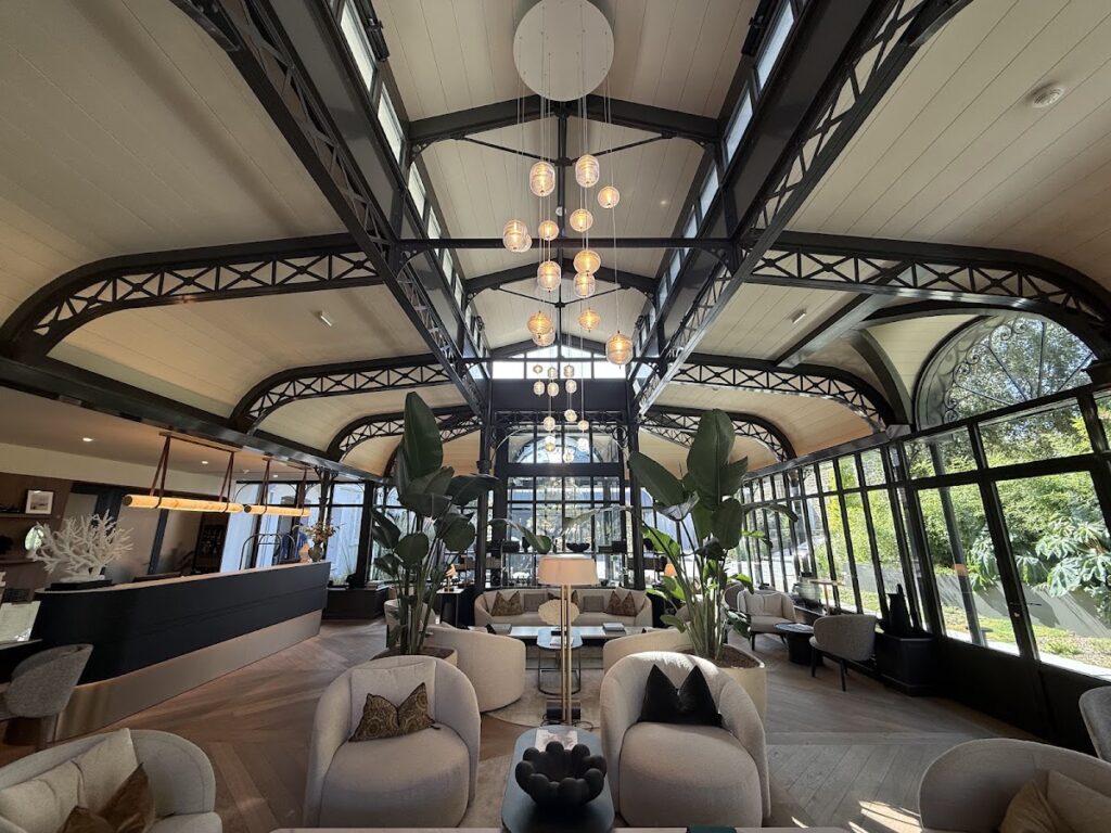 Grand Hotel de Courtoisville airy lobby with steel beams and