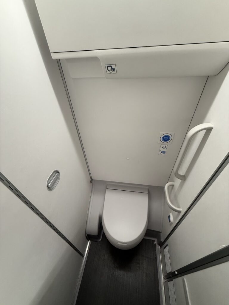 Aircraft lavatory interior with modern white fixtures