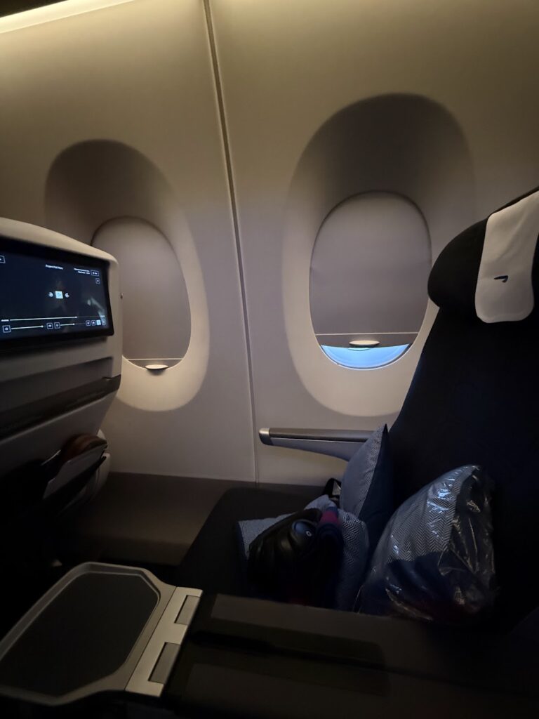 BA premium economy seat with personal screen and window view