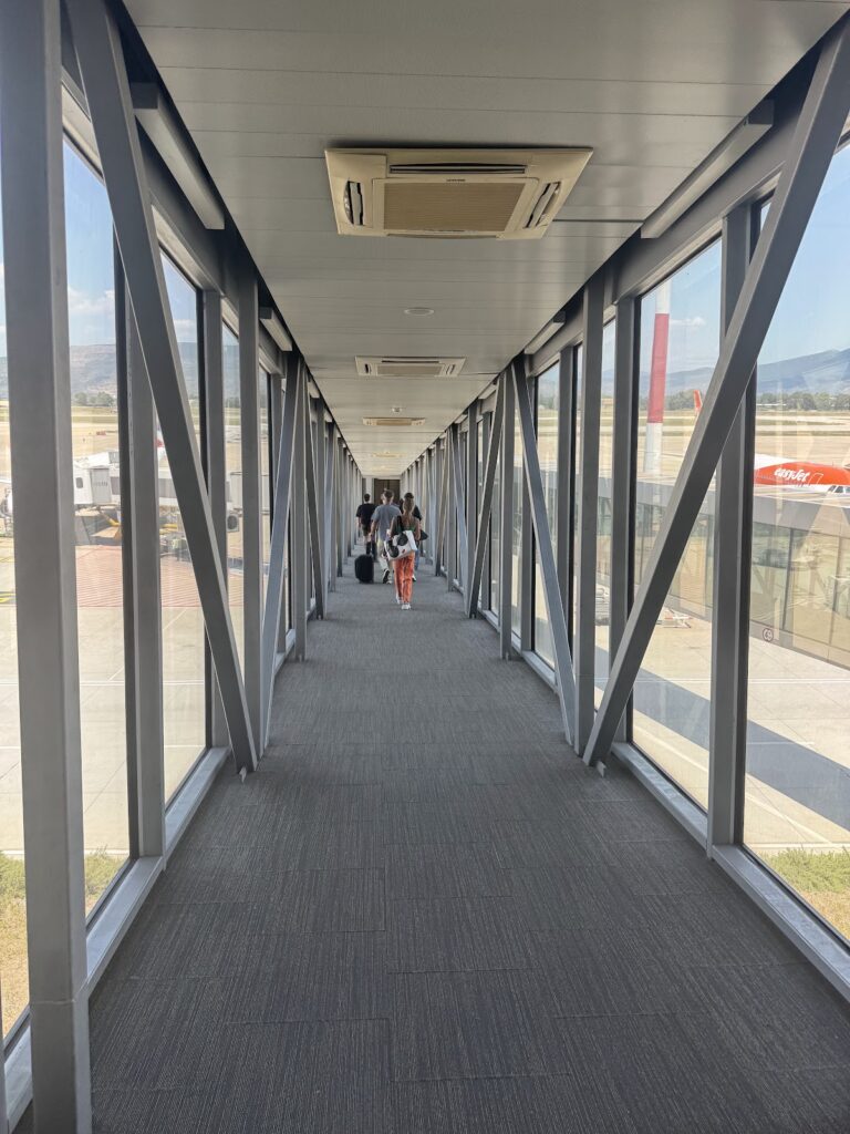 Airport jet bridge corridor with boarding passengers